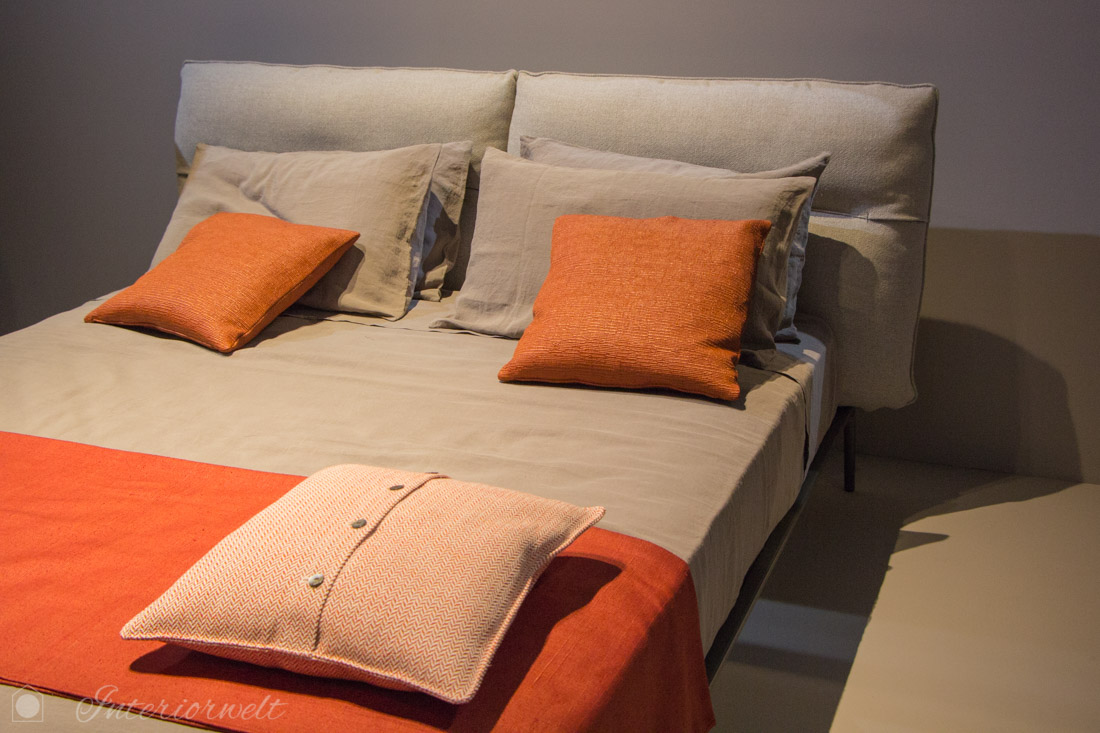 Orange Kissen auf Bett